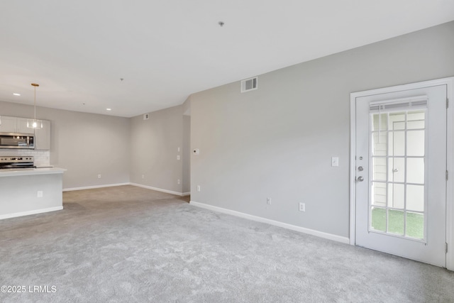 unfurnished living room featuring light colored carpet