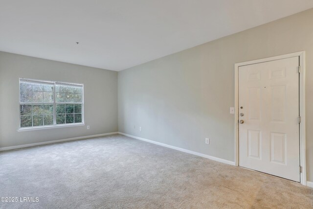 spare room featuring light carpet