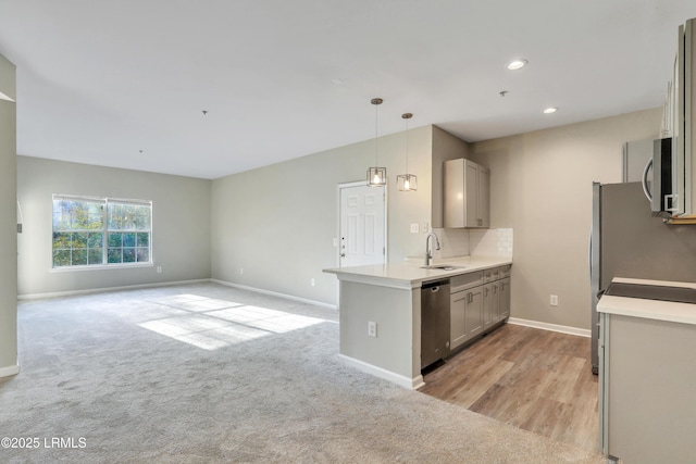 kitchen featuring gray cabinetry, sink, pendant lighting, and appliances with stainless steel finishes