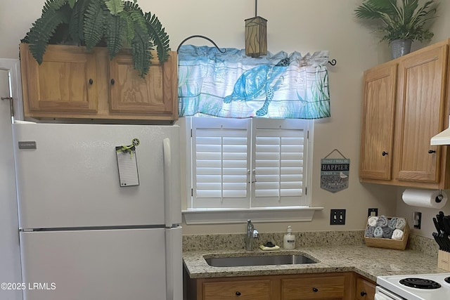 kitchen featuring pendant lighting, white appliances, and sink