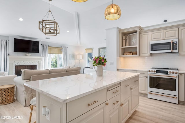 kitchen with open floor plan, white appliances, light wood-style flooring, and tasteful backsplash