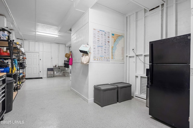 interior space with speckled floor and freestanding refrigerator