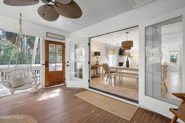 doorway to outside with a ceiling fan, a healthy amount of sunlight, and wood finished floors