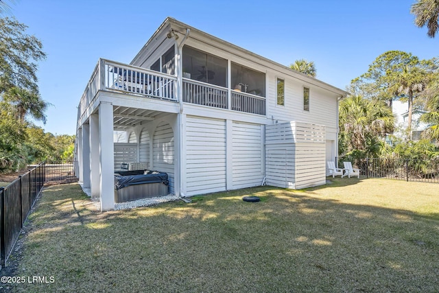 back of house with a sunroom, a fenced backyard, and a yard