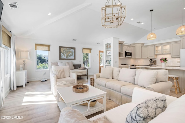 living area with high vaulted ceiling, light wood-type flooring, visible vents, and recessed lighting