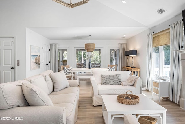 living area featuring recessed lighting, visible vents, vaulted ceiling, and light wood-style flooring