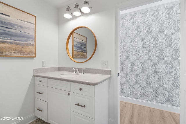 full bathroom with wood finished floors, vanity, and baseboards