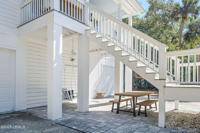 view of patio with a garage and stairway