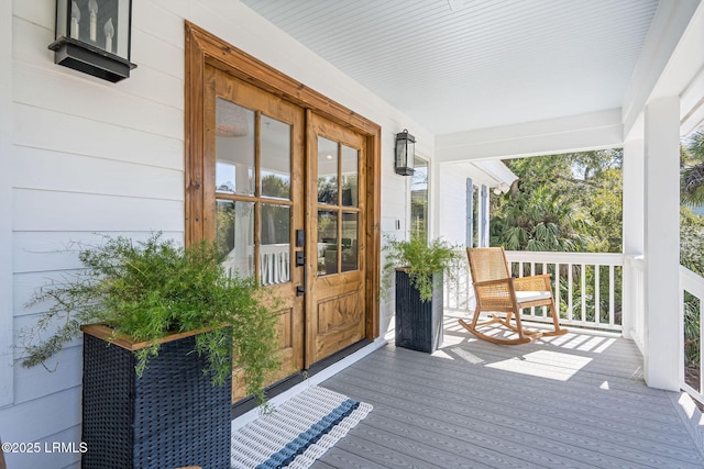 wooden terrace featuring french doors and covered porch