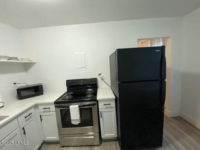 1712 Battery Park Dr, Port Royal, SC 29935 - kitchen featuring black appliances, light wood-style flooring, light countertops, white cabinetry, and open shelves