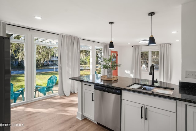 kitchen featuring pendant lighting, sink, dishwasher, dark stone countertops, and white cabinets