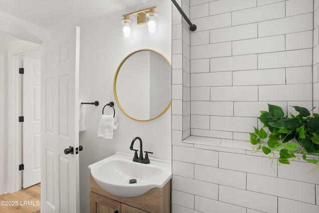 bathroom with vanity, hardwood / wood-style floors, and tile walls