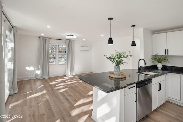 kitchen with white cabinetry, sink, dark stone countertops, stainless steel dishwasher, and kitchen peninsula