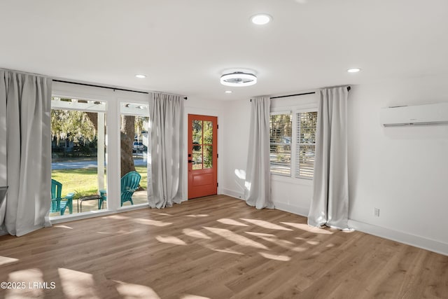 entryway with a wall mounted air conditioner and wood-type flooring