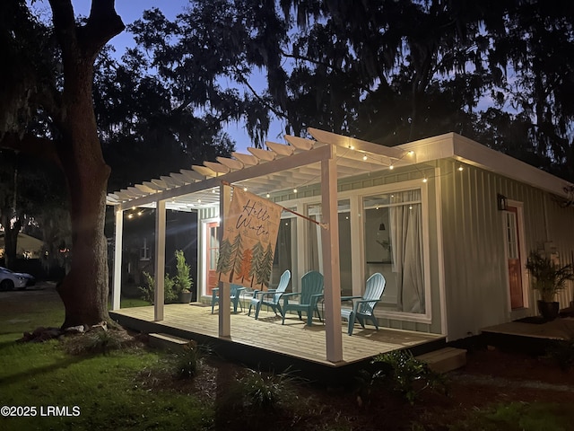 back of property featuring a deck and a pergola