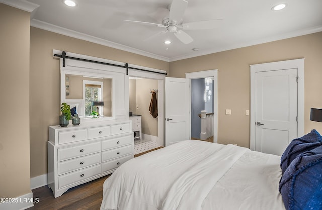 bedroom featuring ornamental molding, a barn door, and recessed lighting