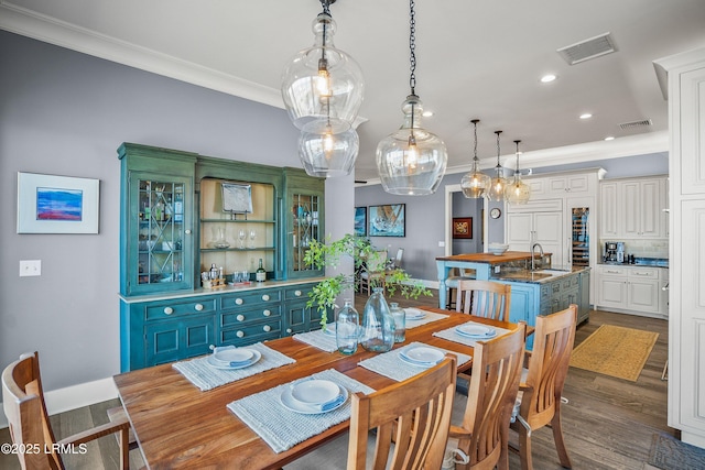 dining room with recessed lighting, visible vents, dark wood-type flooring, and ornamental molding