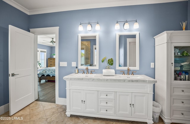 ensuite bathroom featuring ornamental molding, double vanity, a sink, and ensuite bathroom