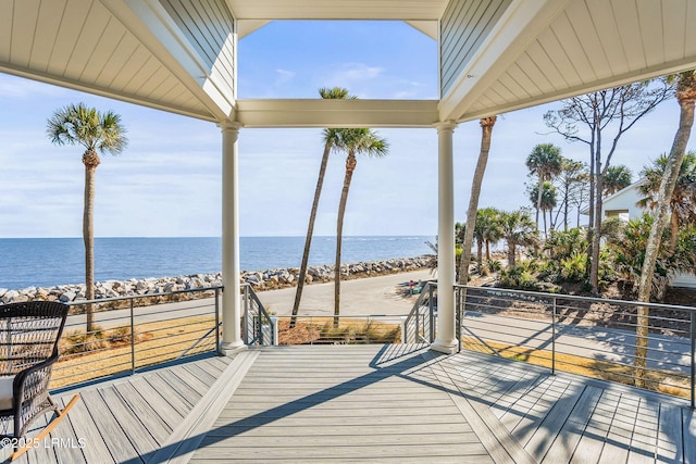 wooden deck with a beach view and a water view