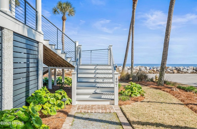 view of yard featuring a water view and stairs