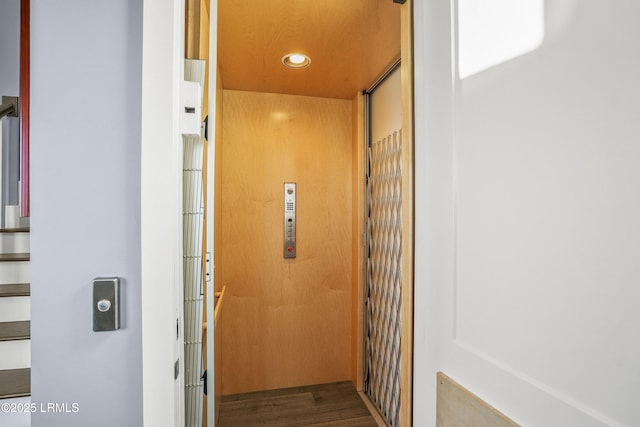 details featuring elevator, wood finished floors, and recessed lighting