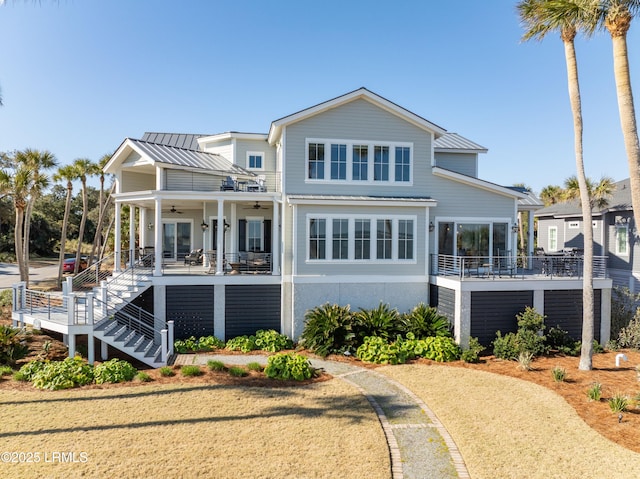 exterior space with metal roof, a porch, a ceiling fan, stairs, and a standing seam roof