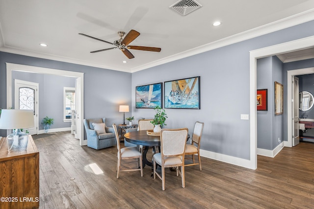 dining area featuring dark wood-style floors, visible vents, crown molding, and baseboards