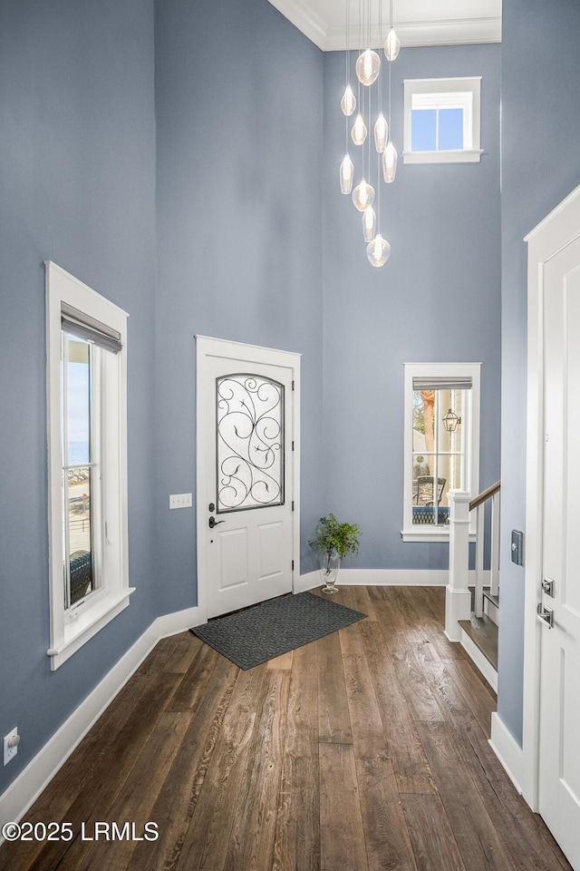 foyer with a high ceiling, baseboards, and dark wood-style flooring