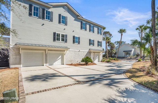 view of front of house with driveway, an attached garage, and stucco siding