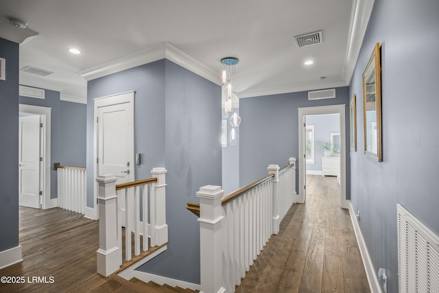 hall featuring visible vents, ornamental molding, dark wood-style floors, and an upstairs landing