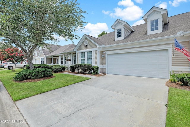 cape cod home featuring a front yard, an attached garage, driveway, and roof with shingles