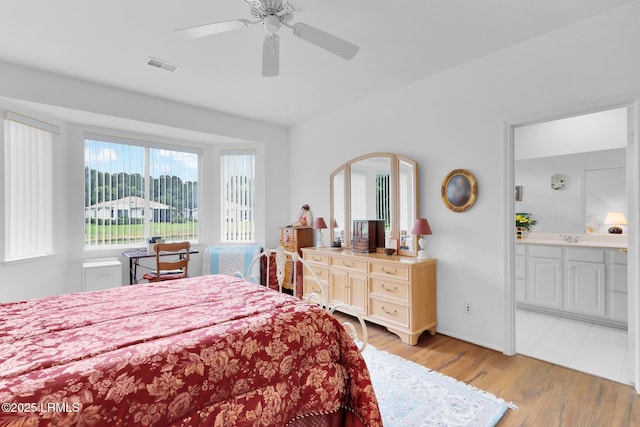 bedroom with visible vents, light wood-style flooring, connected bathroom, and ceiling fan