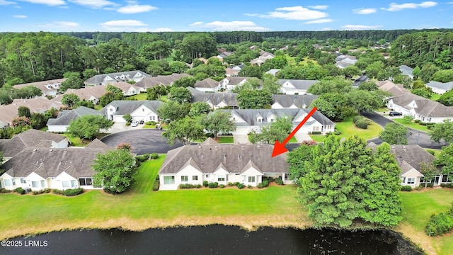 aerial view with a residential view, a view of trees, and a water view