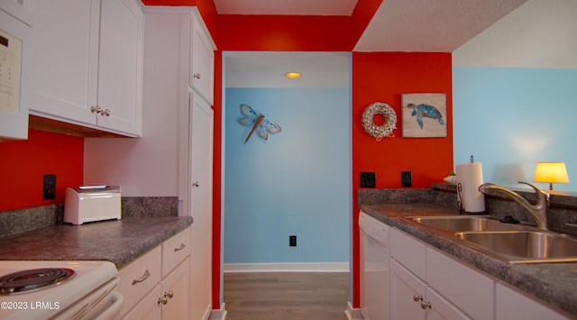 kitchen featuring dishwasher, sink, white cabinets, and dark hardwood / wood-style floors