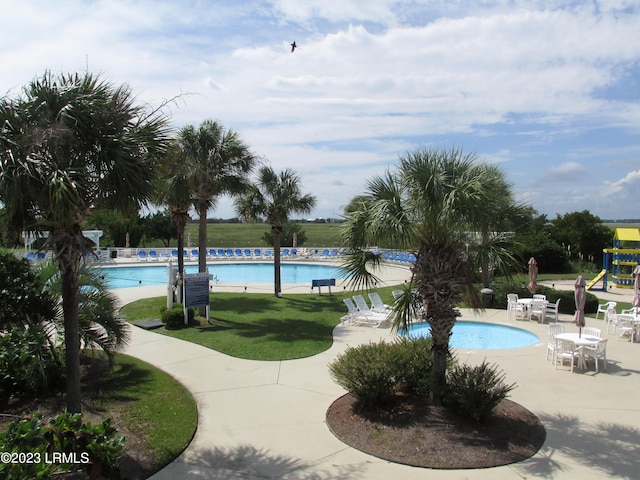 view of pool with a playground, a yard, and a patio area