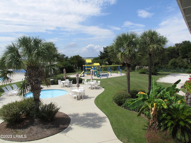 view of pool with a patio, a playground, and a lawn