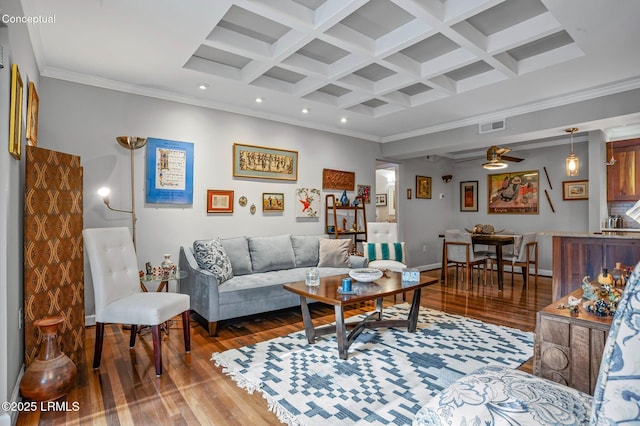 living area featuring ornamental molding, coffered ceiling, wood finished floors, and visible vents