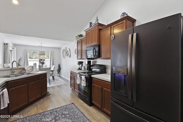 2110 River Rock Way, Beaufort, SC 29902 - kitchen with black appliances, light wood finished floors, light countertops, and decorative light fixtures