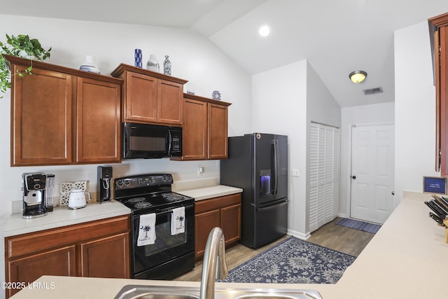 2110 River Rock Way, Beaufort, SC 29902 - kitchen with black appliances, vaulted ceiling, light countertops, and light wood finished floors