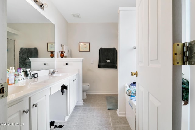 bathroom with vanity, toilet, a shower with shower door, and tile patterned flooring