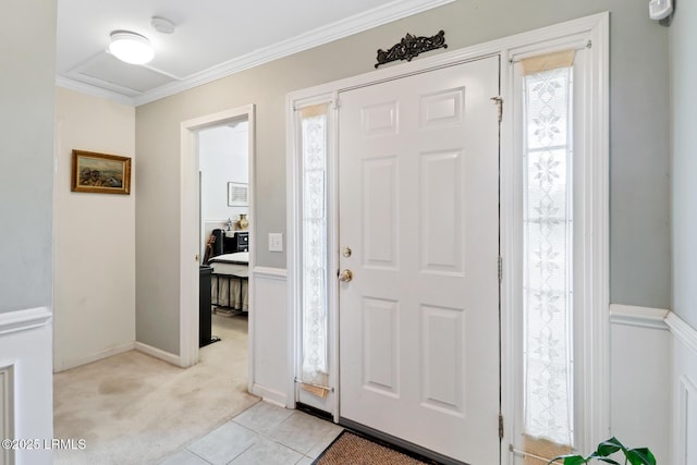 foyer entrance with ornamental molding, a wealth of natural light, and light colored carpet