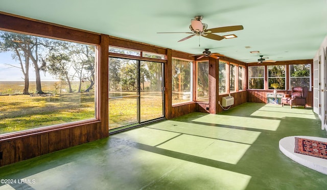 unfurnished sunroom featuring plenty of natural light and a wall unit AC