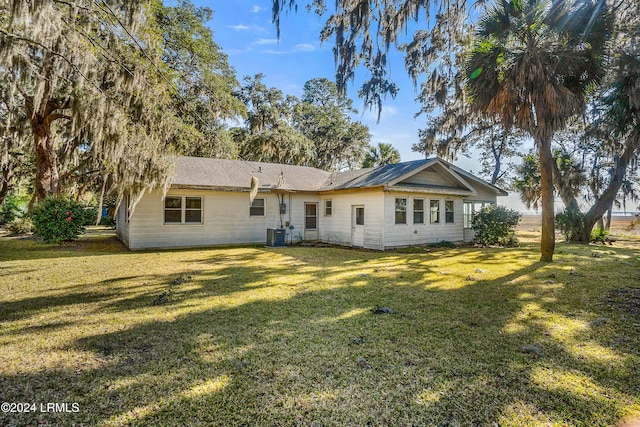 back of house featuring a yard and central air condition unit