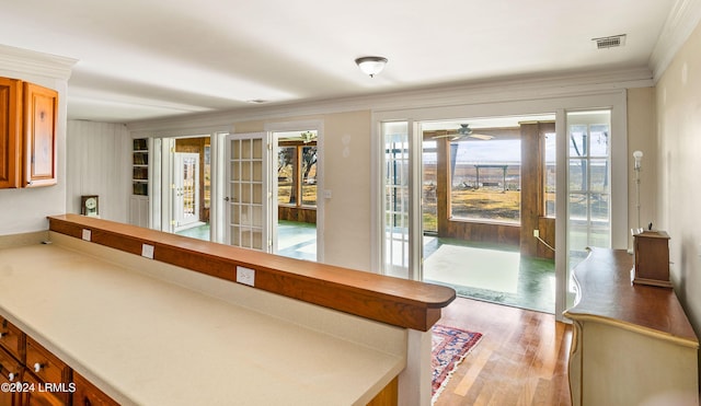 doorway to outside featuring crown molding and light wood-type flooring