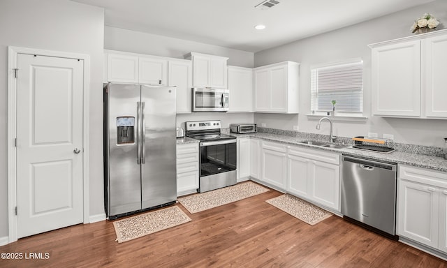 42 Pacolet Ln, Beaufort, SC 29906 - kitchen featuring wood finished floors, white cabinetry, a sink, and appliances with stainless steel finishes