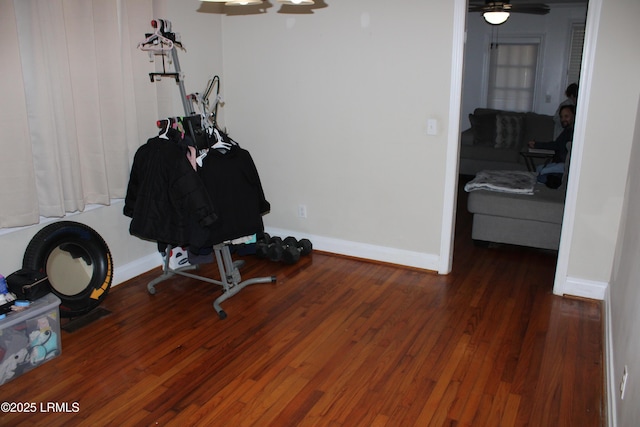 workout room featuring wood finished floors and baseboards