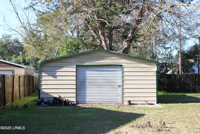 view of outdoor structure featuring fence and an outbuilding