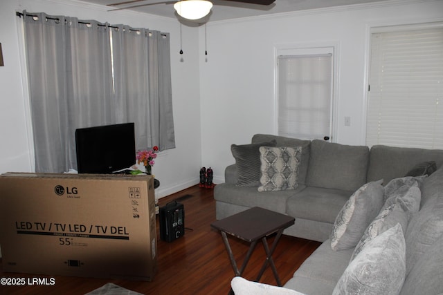 living room with baseboards, ceiling fan, wood finished floors, and crown molding