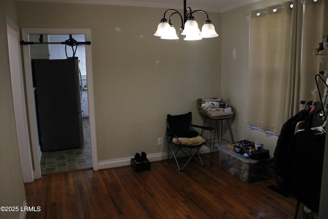 unfurnished dining area with a chandelier, ornamental molding, wood finished floors, and baseboards