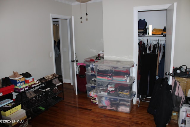 bedroom with ornamental molding, a closet, and wood finished floors